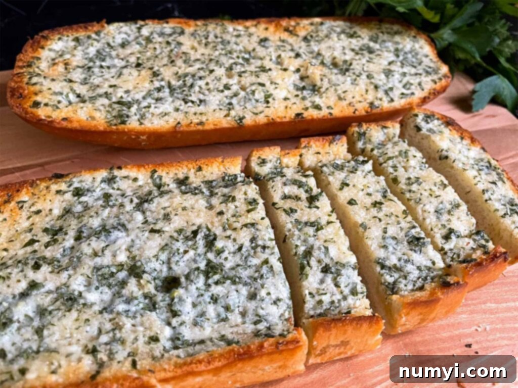 A large, rustic loaf of homemade garlic bread, perfectly golden and sliced, resting on a wooden cutting board, with fresh parsley garnish.