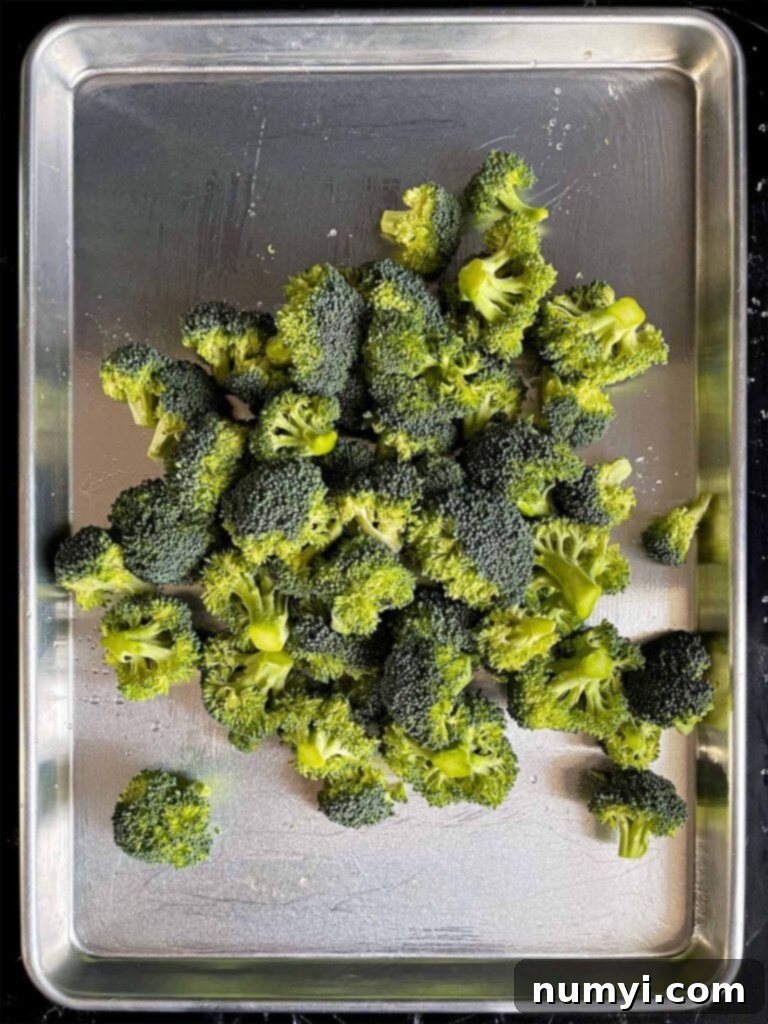 Crispy Oven Roasted Broccoli 4 Broccoli florets on a baking sheet.