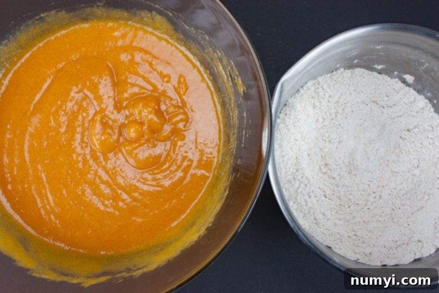Ultimate Pumpkin Muffins 3 Bakery Style Pumpkin Muffins - wet ingredients combined in a glass bowl next to dry ingredients combined in a metal bowl, ready to be mixed.