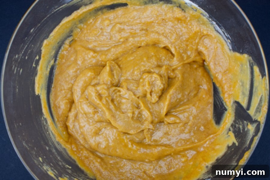 Ultimate Pumpkin Muffins 4 Bakery Style Pumpkin Muffins batter in a glass mixing bowl, perfectly combined and ready for the muffin tin.