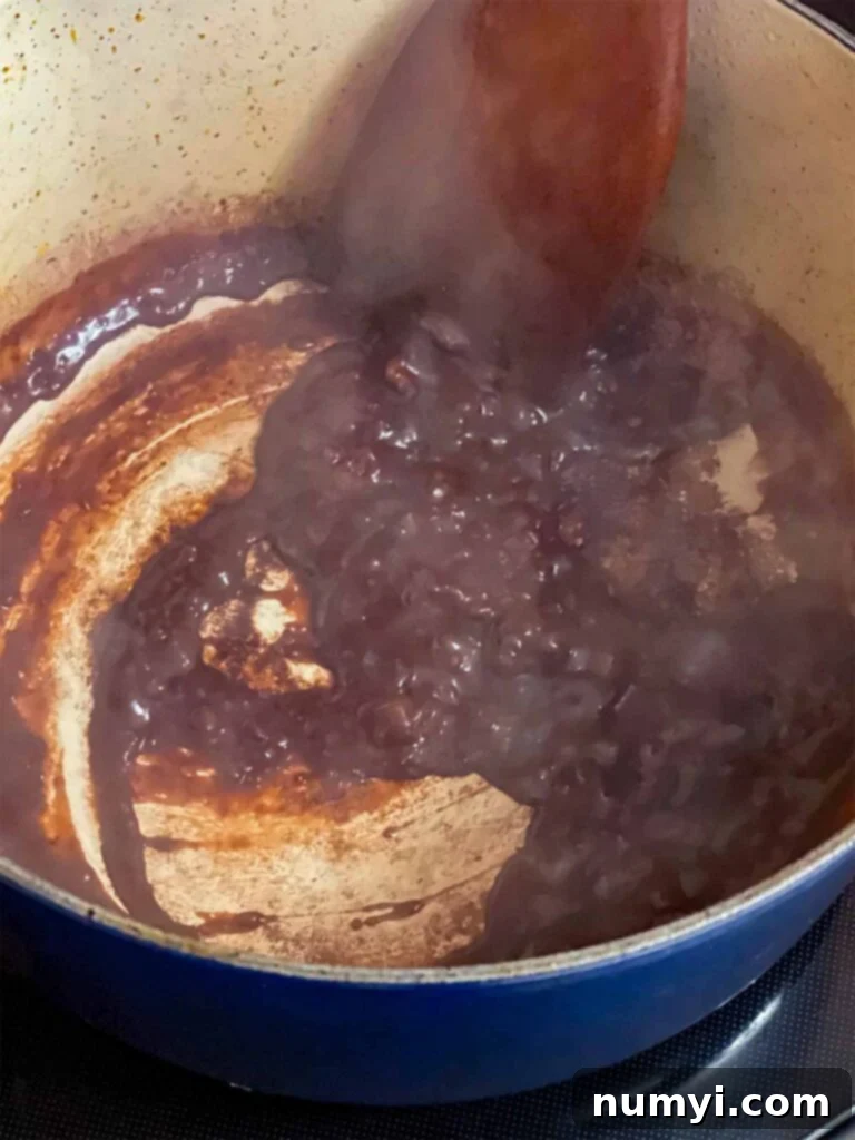 Grandma's Hearty Pot Roast 5 Red wine reducing in the dutch oven with the other ingredients for the pot roast recipe.