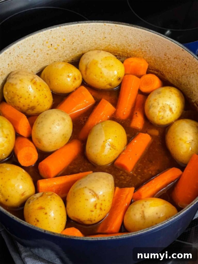 Grandma's Hearty Pot Roast 8 Potatoes and carrots added to the dutch oven with the pot roast.