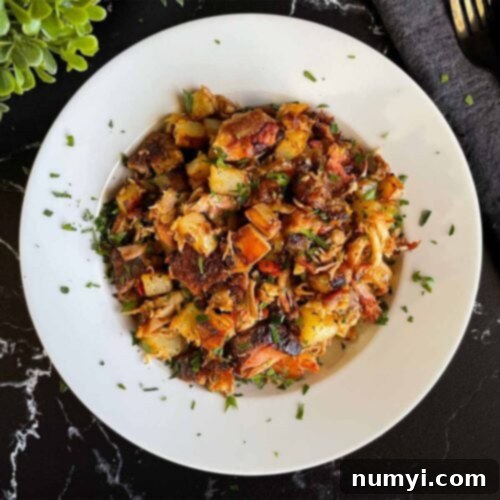 Hearty Smoked Pulled Pork Hash 12 Smoked pulled pork hash garnished with parsley in a white bowl.