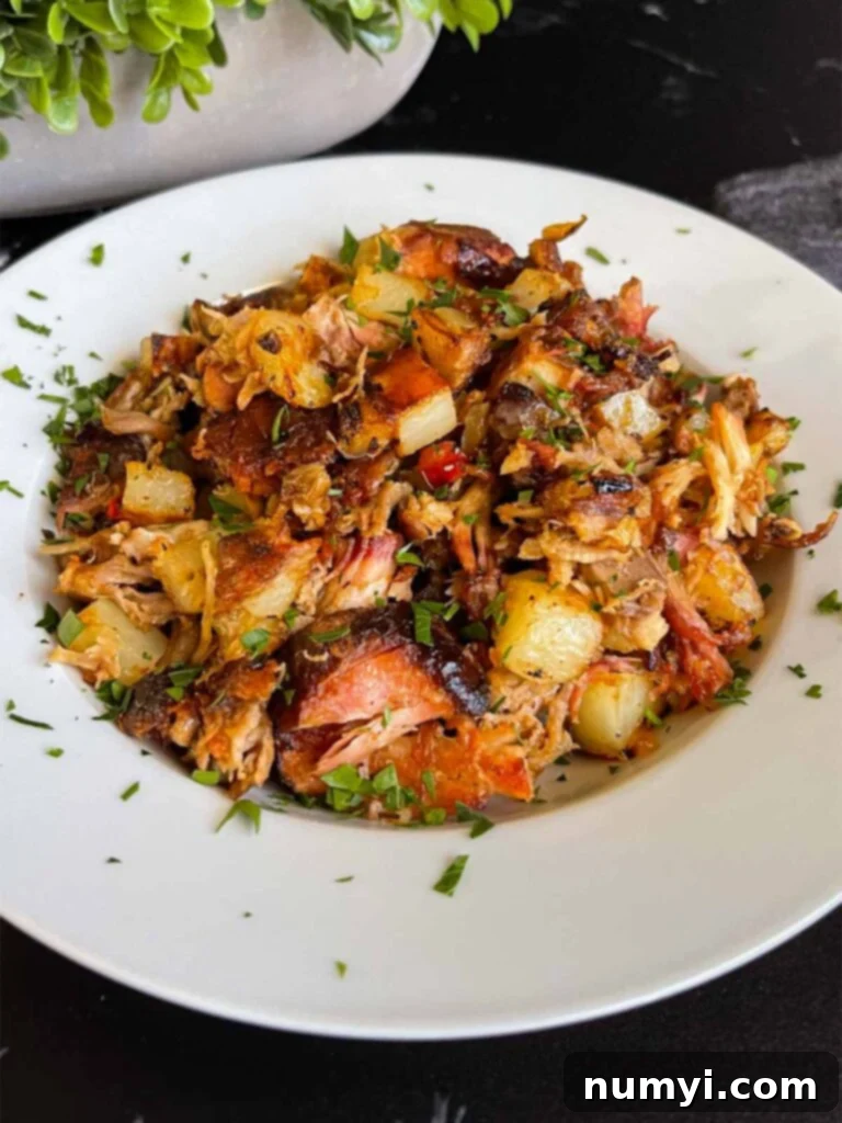Hearty Smoked Pulled Pork Hash 10 Smoked pulled pork hash garnished with parsley in a white bowl.