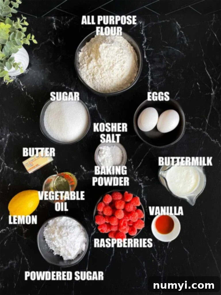 Raspberry muffin recipe ingredients laid out on a dark surface.