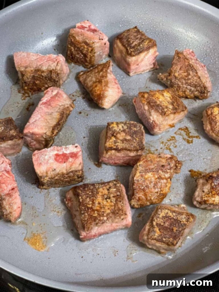 Seared beef tips in a skillet.