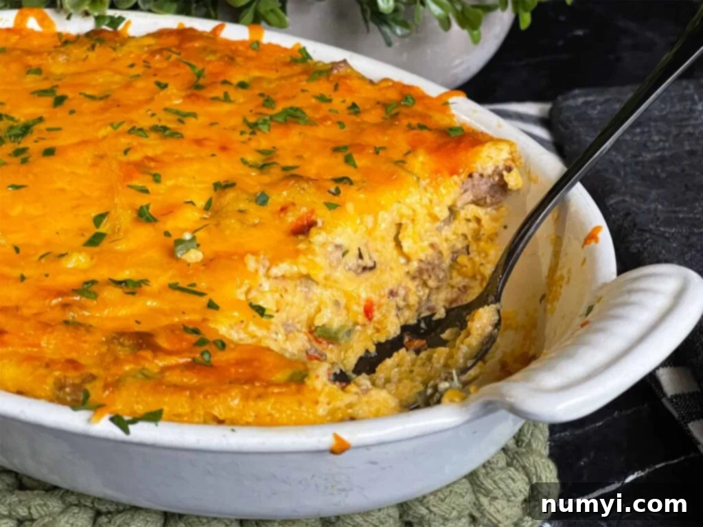 Cheesy Sausage Grits Bake 2 Baked sausage and cheese grits in a casserole dish with a serving cut out.