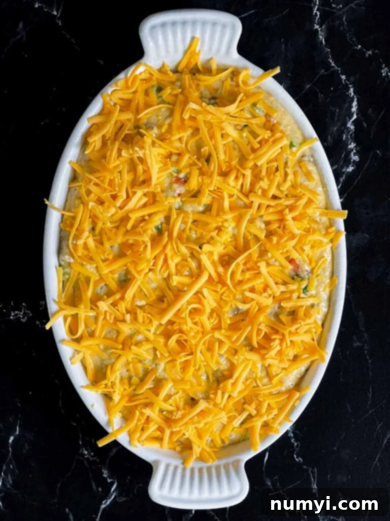 Cheesy Sausage Grits Bake 12 Sausage and cheese grits in a casserole dish, topped with shredded cheddar cheese.