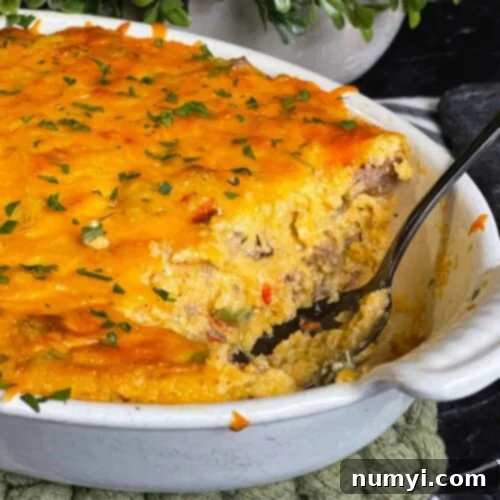 Cheesy Sausage Grits Bake 16 Baked sausage and cheese grits in a casserole dish with a serving cut out.