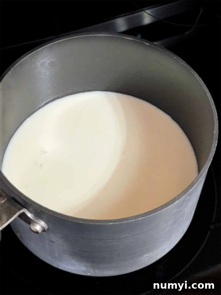 Cheesy Sausage Grits Bake 6 Milk in a saucepan.