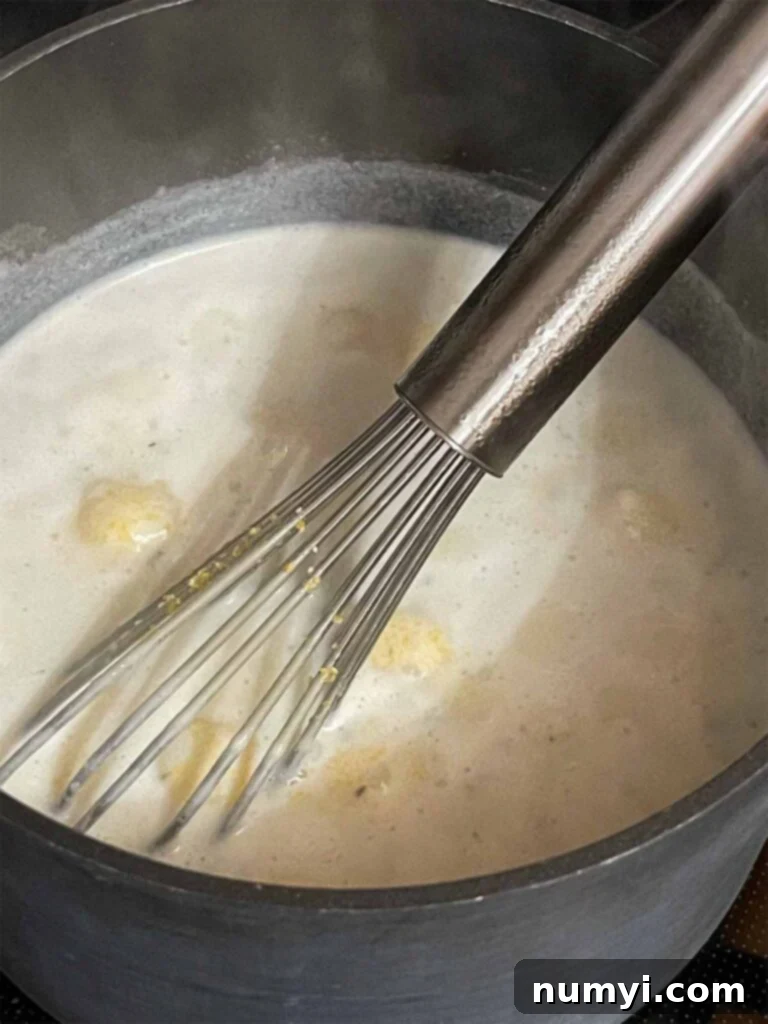 Cheesy Sausage Grits Bake 8 Grits cooking in a saucepan.