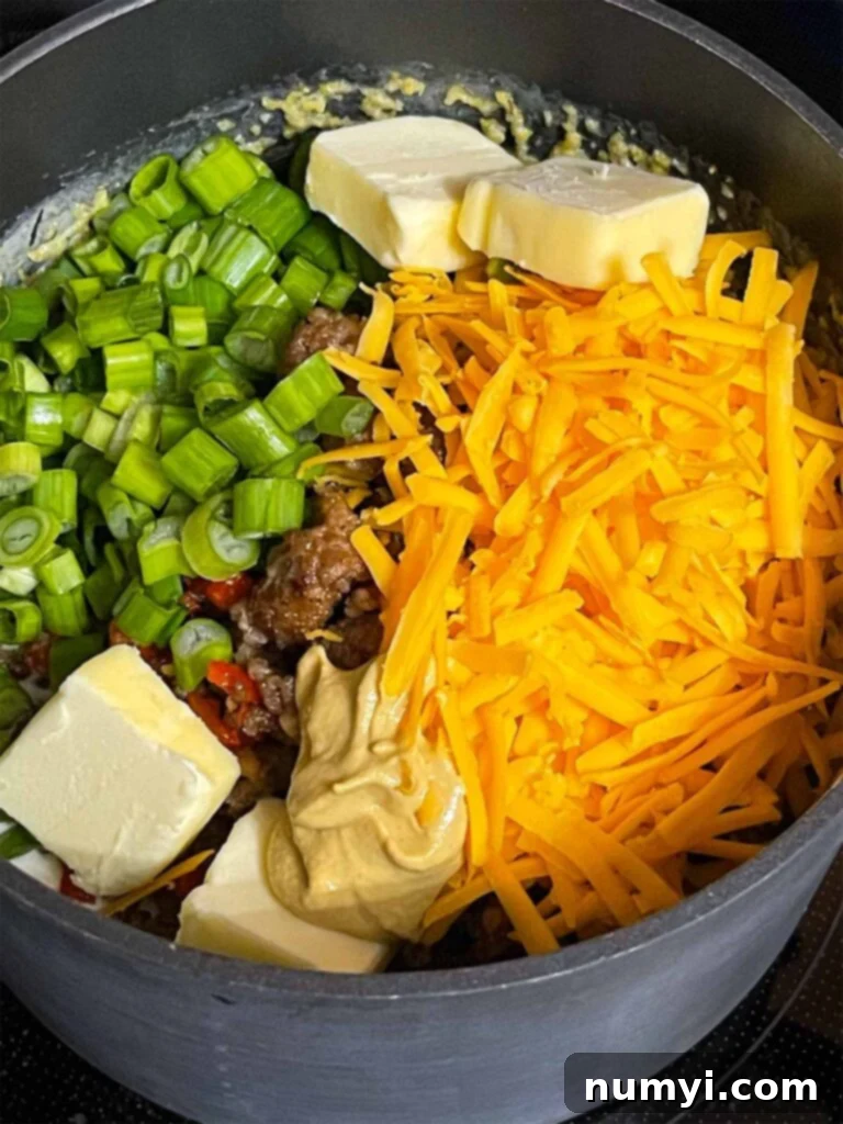 Cheesy Sausage Grits Bake 10 Additional items being tossed into a saucepan of grits.