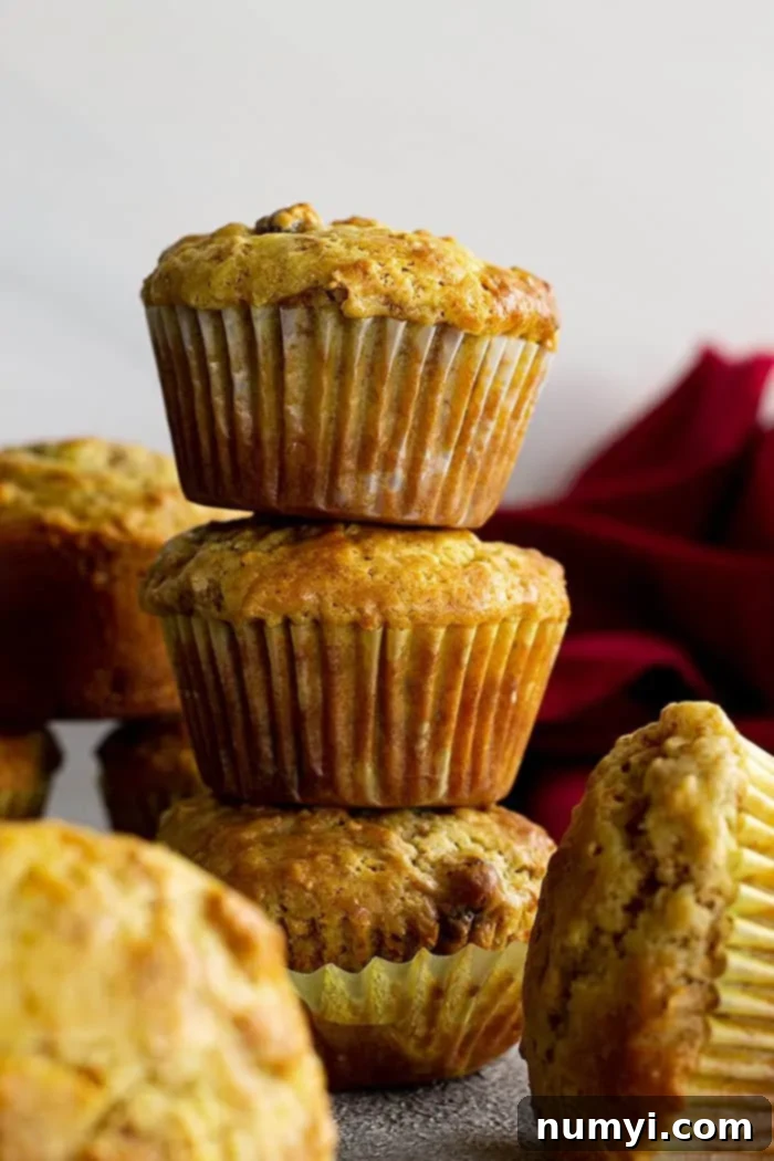 Stacked, golden-brown Raisin Bran Muffins, showcasing their fluffy texture and delicious raisins, ready to be enjoyed.