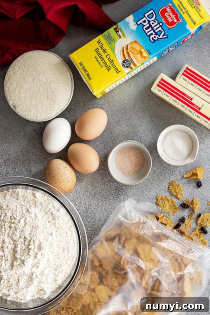 Fresh ingredients laid out for making Raisin Bran Muffins, including a box of cereal, buttermilk, eggs, and flour.
