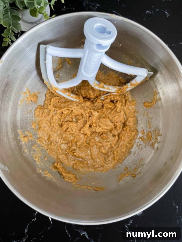 Wet ingredients for oatmeal fudge bars mixed in a metal mixing bowl.