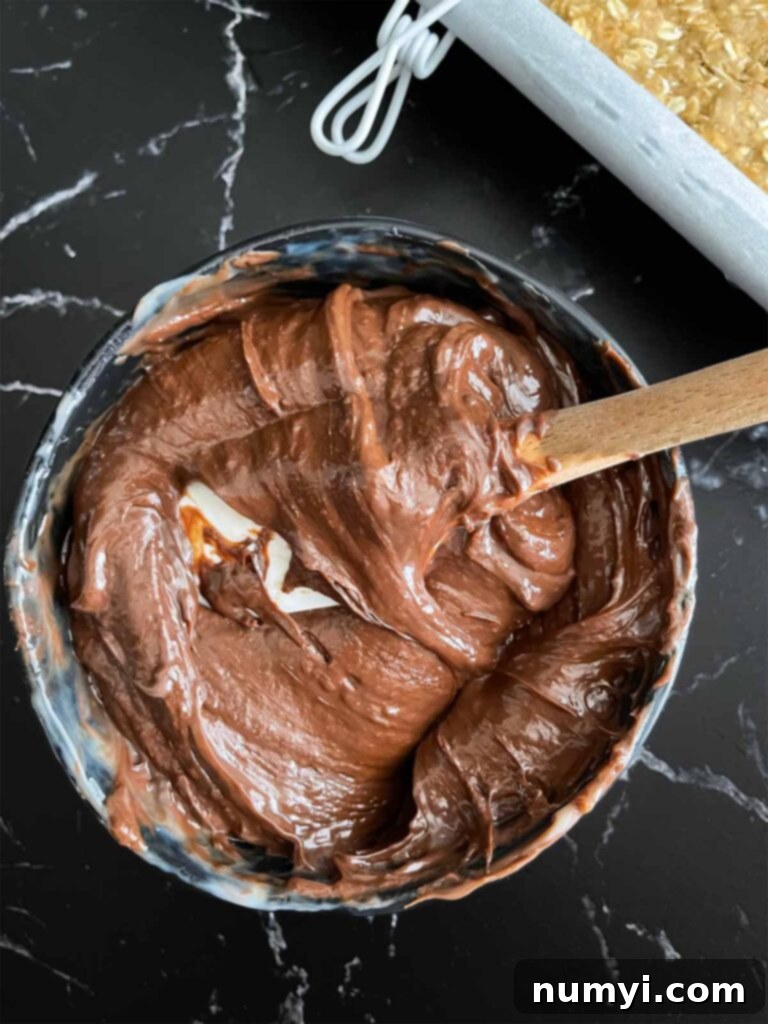 Fudge ingredients melted in a dark bowl on a dark surface.