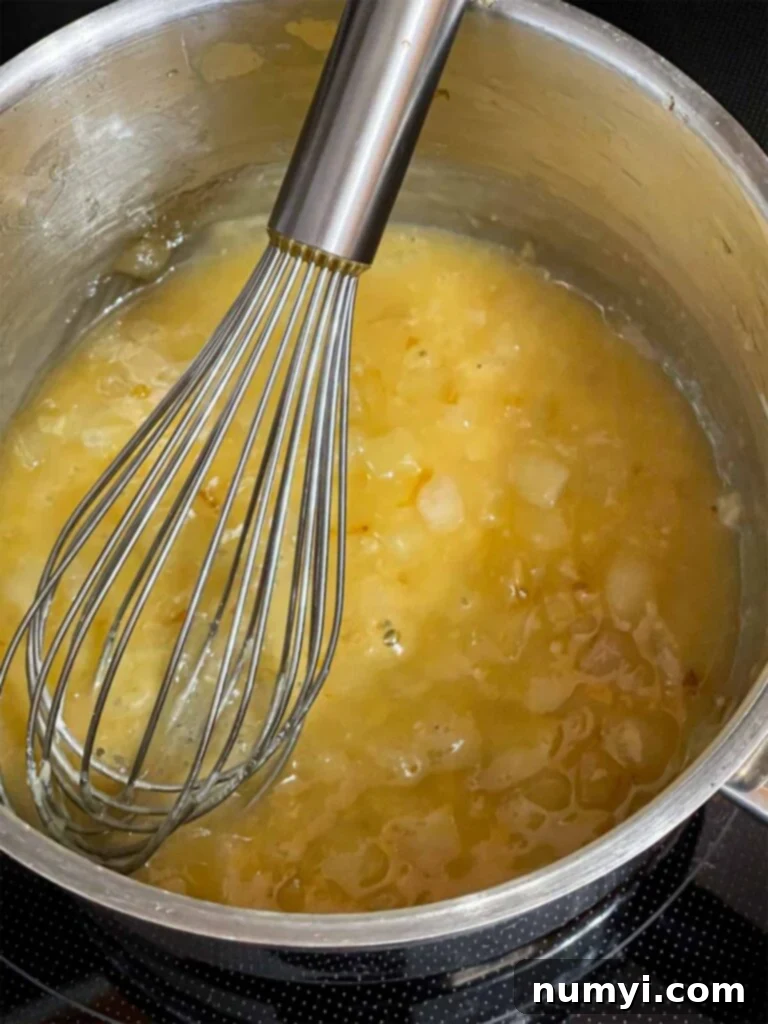 A roux (butter and flour mixture) cooking in a pot, thickening for the Tetrazzini sauce.