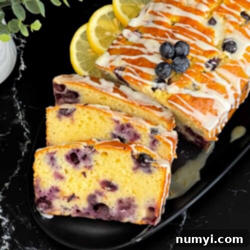 Sliced blueberry bread on a dark platter on a dark surface.
