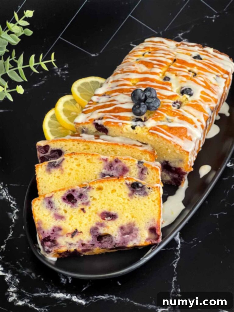 Sliced blueberry bread on a dark platter on a dark surface.