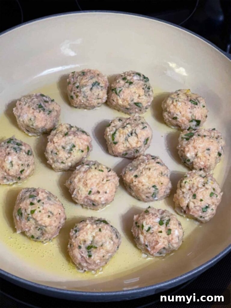 Chicken Piccata Meatballs cooking in a skillet.