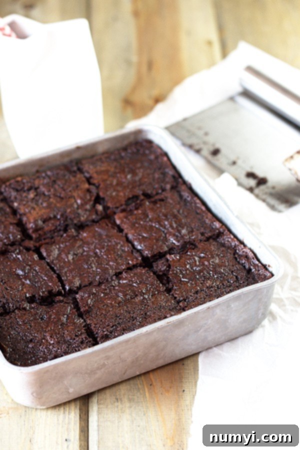 A silver dish brimming with perfectly cut, rich, fudgy zucchini brownies, ready to be enjoyed.