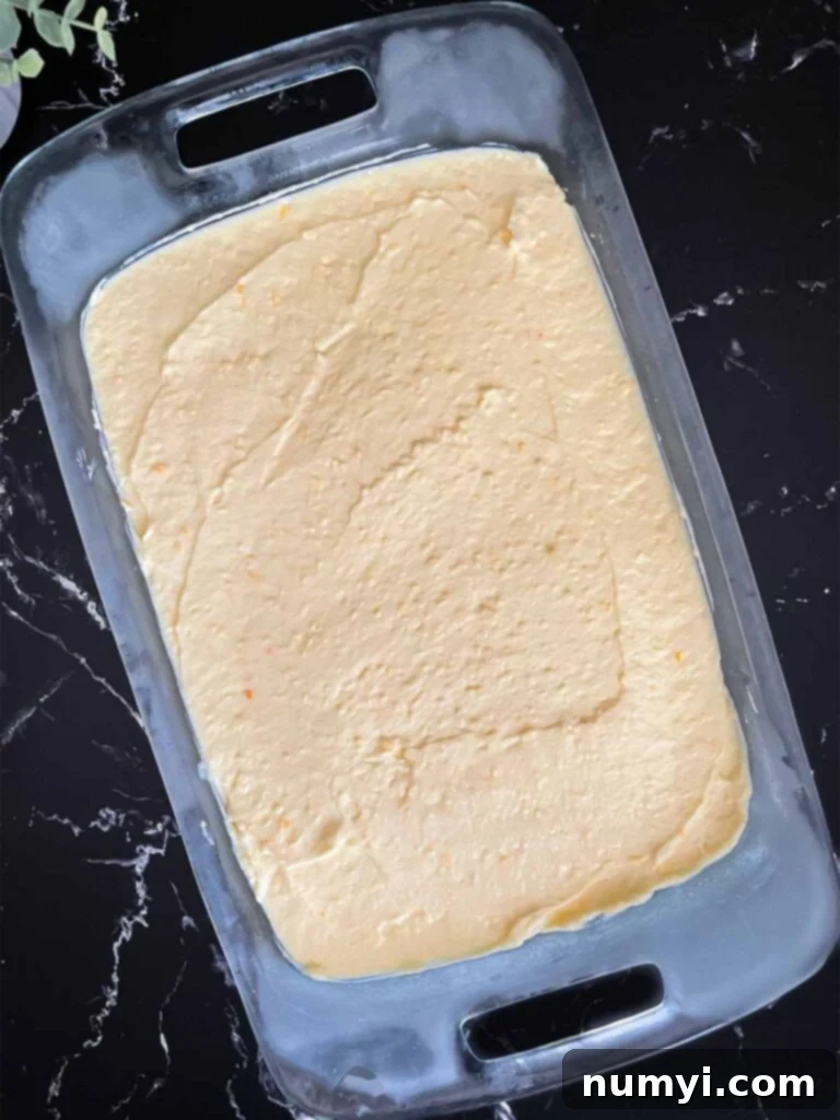 Lush Coconut Cream 9 Coconut cream pudding mixture spread over the cheesecake layer in a glass baking pan.