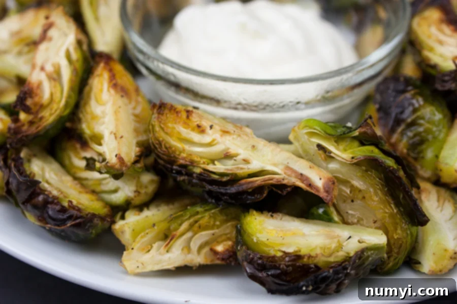 Roasted Brussel Sprouts with Aioli Dipping Sauce served on a white plate, ready to be enjoyed.