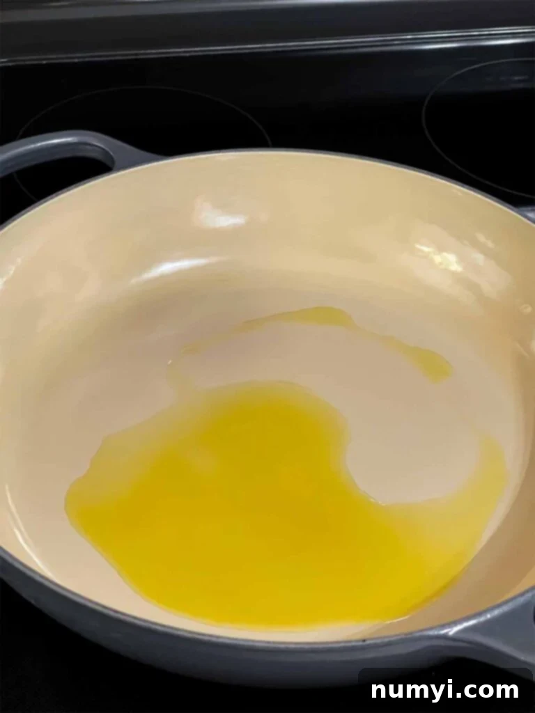 Olive oil heating in a skillet.