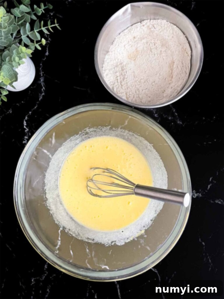 Wet ingredients mixed in a glass bowl and dry ingredients mixed in a metal bowl, ready for combining.