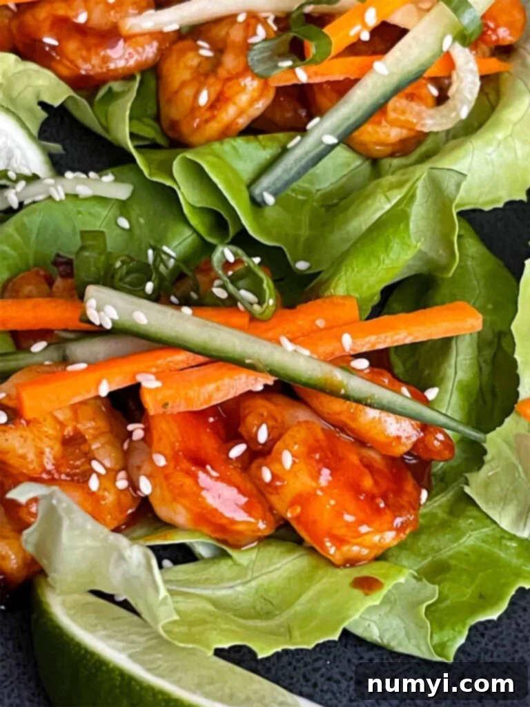 Close-up of a vibrant Gochujang shrimp lettuce wrap with fresh vegetables, showing the delicious filling.