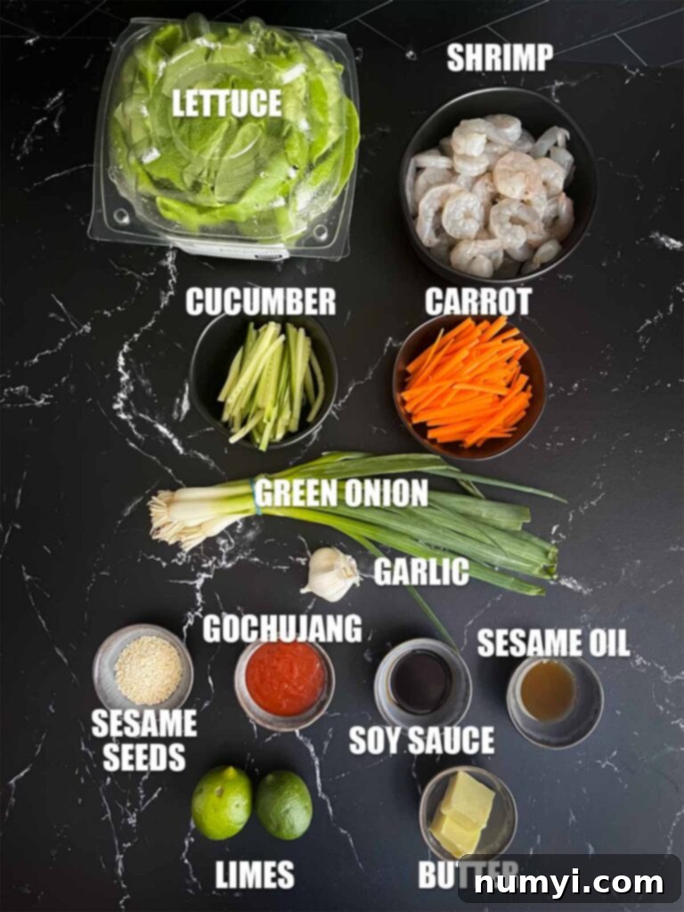 A selection of fresh ingredients including raw shrimp, julienned vegetables, Gochujang, and green onions, laid out on a wooden board ready for preparation.