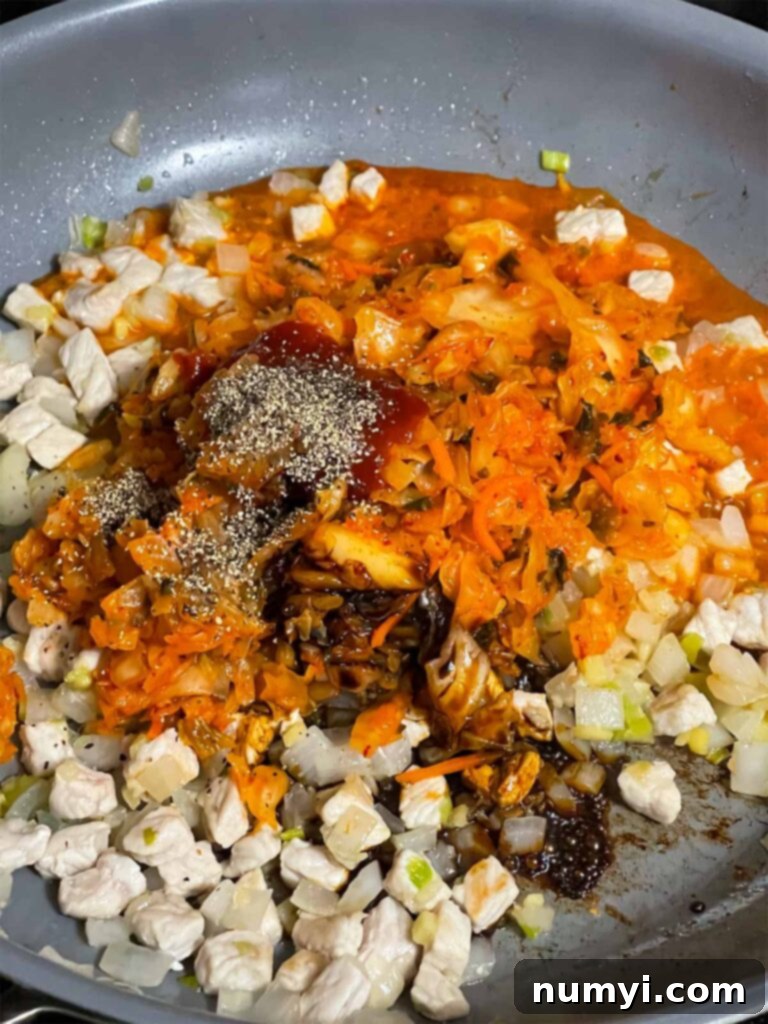 The spicy and tangy kimchi mixture simmering in a skillet, ready for the addition of rice.