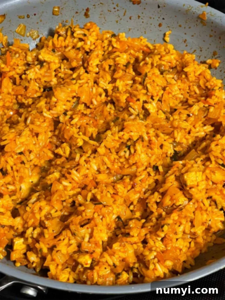 Kimchi fried rice in a skillet, showing the perfectly mixed grains infused with vibrant kimchi flavors.