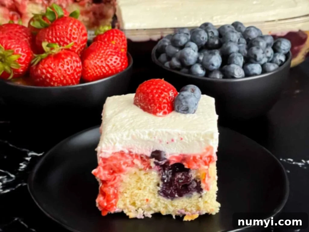 Luscious Berry Poke Cake 2 A vibrant slice of Berry Poke Cake on a dark plate, showing layers of vanilla cake, mixed berry filling, and fluffy cream cheese frosting.