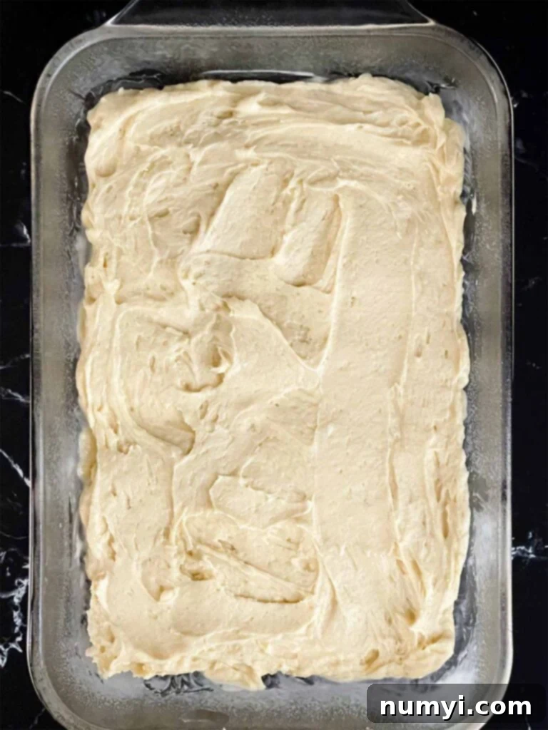 Luscious Berry Poke Cake 7 Smooth vanilla cake batter evenly spread into a prepared 9x13 glass baking pan, ready for the oven, for the berry poke cake recipe.