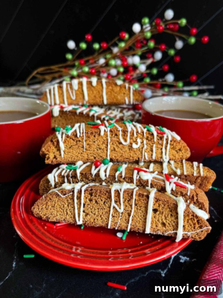 Decorated gingerbread biscotti on small red plates with red coffee mugs.