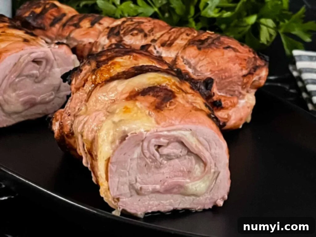 Grilled Cuban Pork Tenderloin, sliced to show the ham and Swiss cheese stuffing.