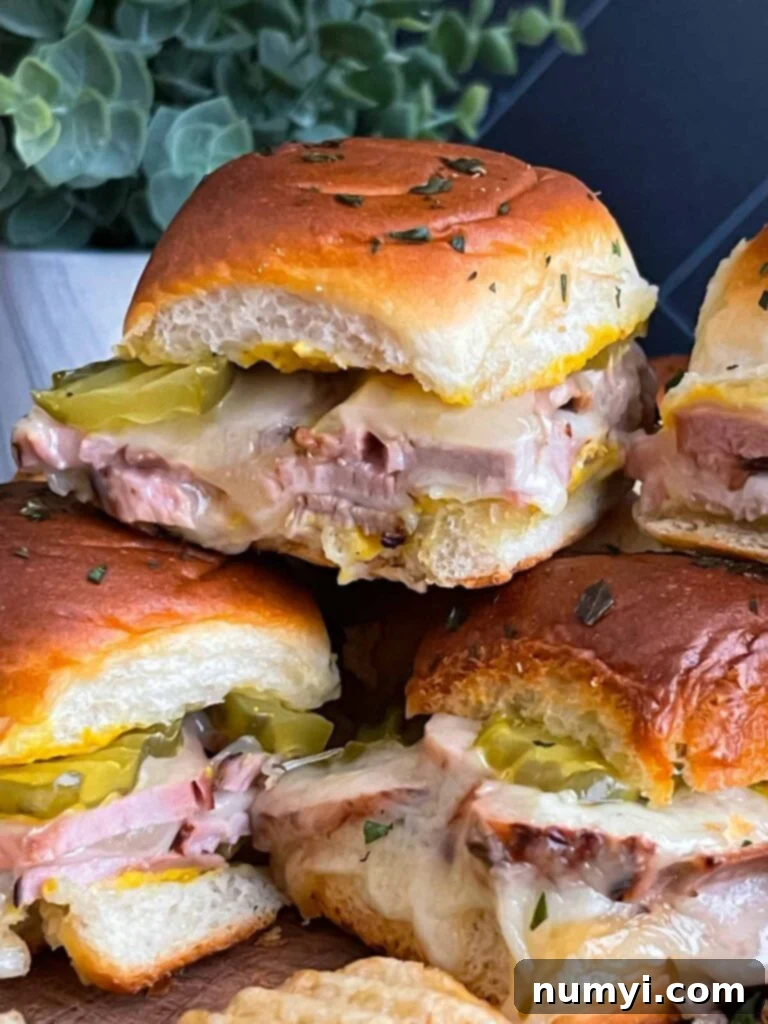 Individual roll-cut pork tenderloin Cuban sliders artfully arranged on a serving platter.