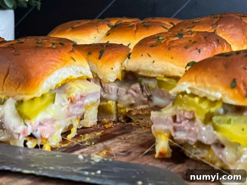 Close-up of a perfectly grilled and sliced roll-cut pork tenderloin Cuban slider, showcasing the layers.