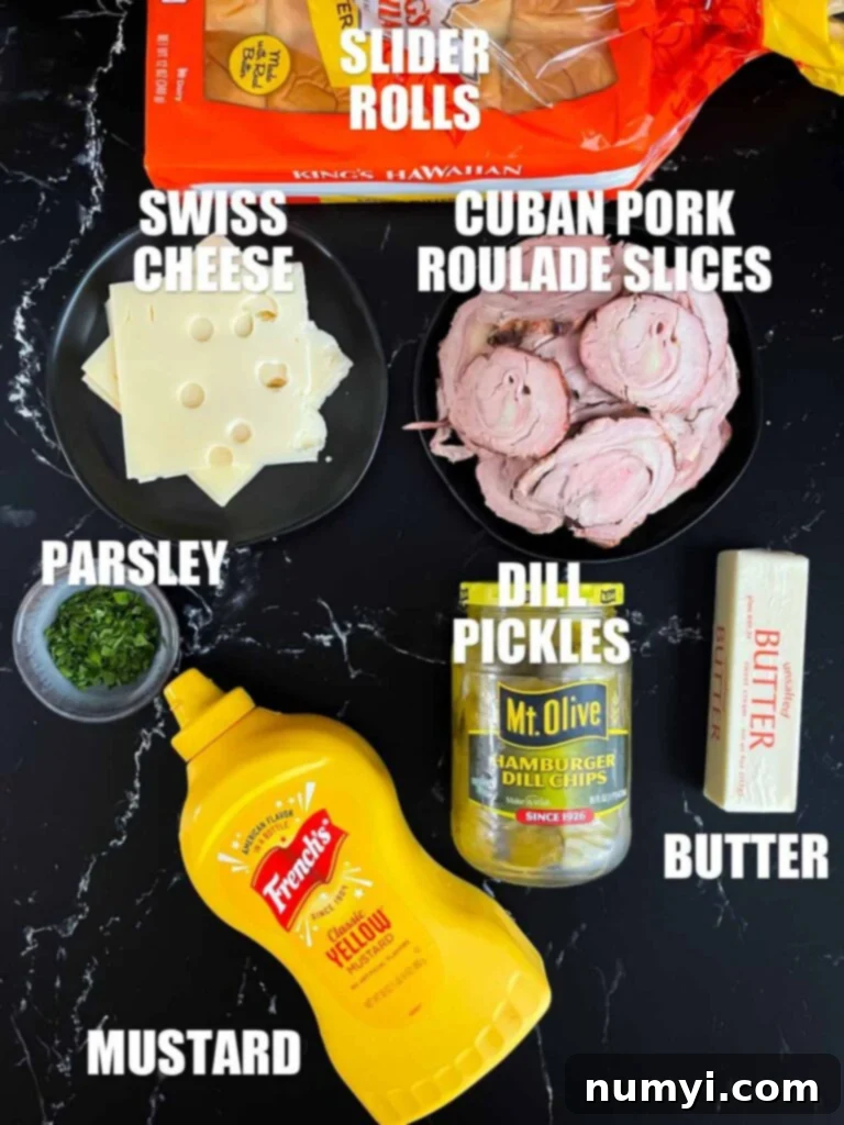 A selection of ingredients laid out on a wooden board, including sliced pork tenderloin, Swiss cheese, mustard, and dill pickles, ready for slider assembly.