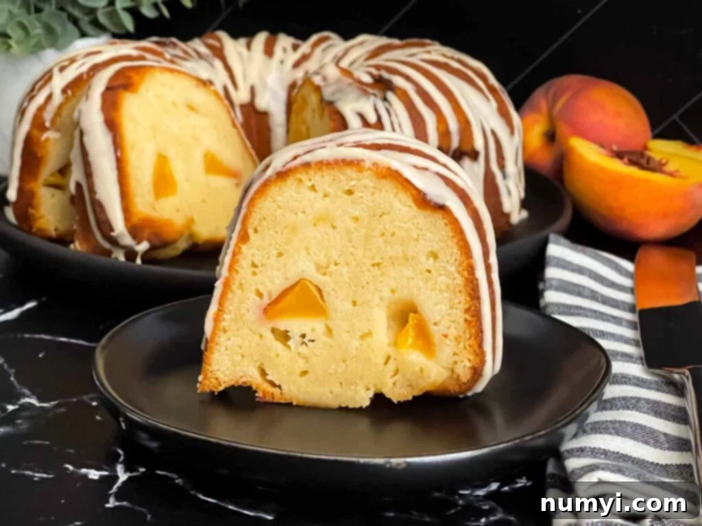 Peach pound cake on a dark plate on a dark surface, beautifully glazed and ready to serve.
