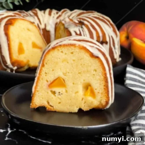 Peach pound cake on a dark plate on a dark surface, beautifully glazed.