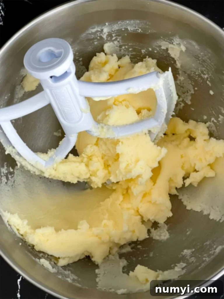 Creamed butter and sugar in a metal mixing bowl for the peach pound cake recipe.