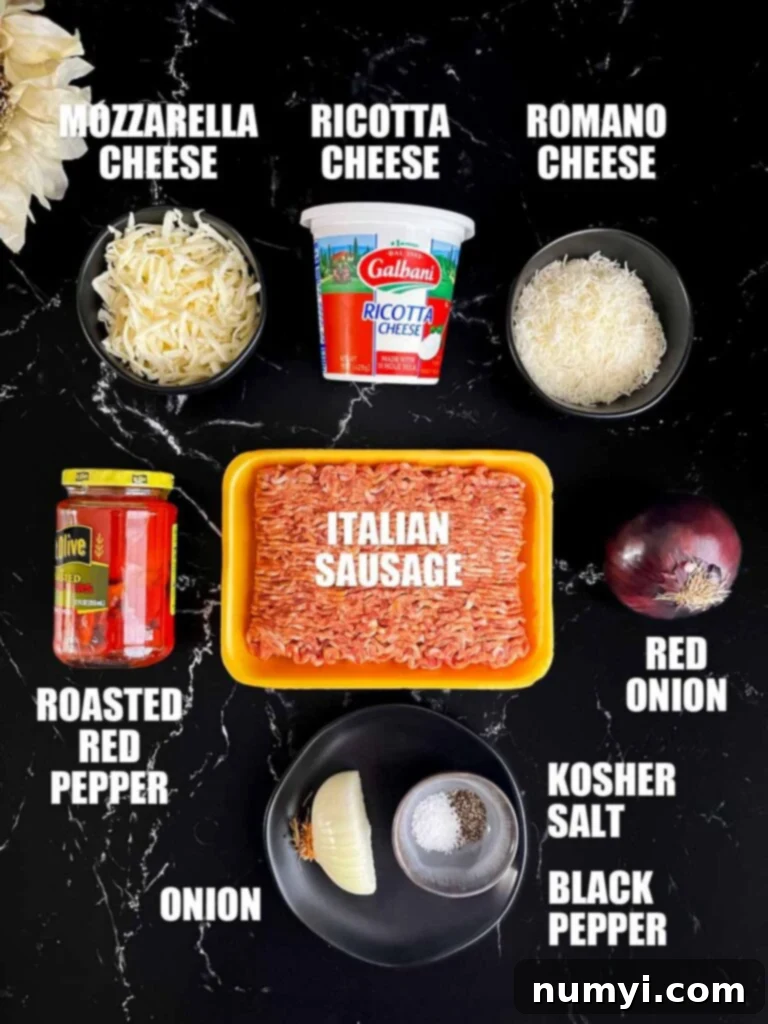 Hearty Italian Sausage Calzone 3 A colorful array of ingredients spread out, including Italian sausage, three types of cheese, red onions, roasted red peppers, and spices, ready for making calzones.