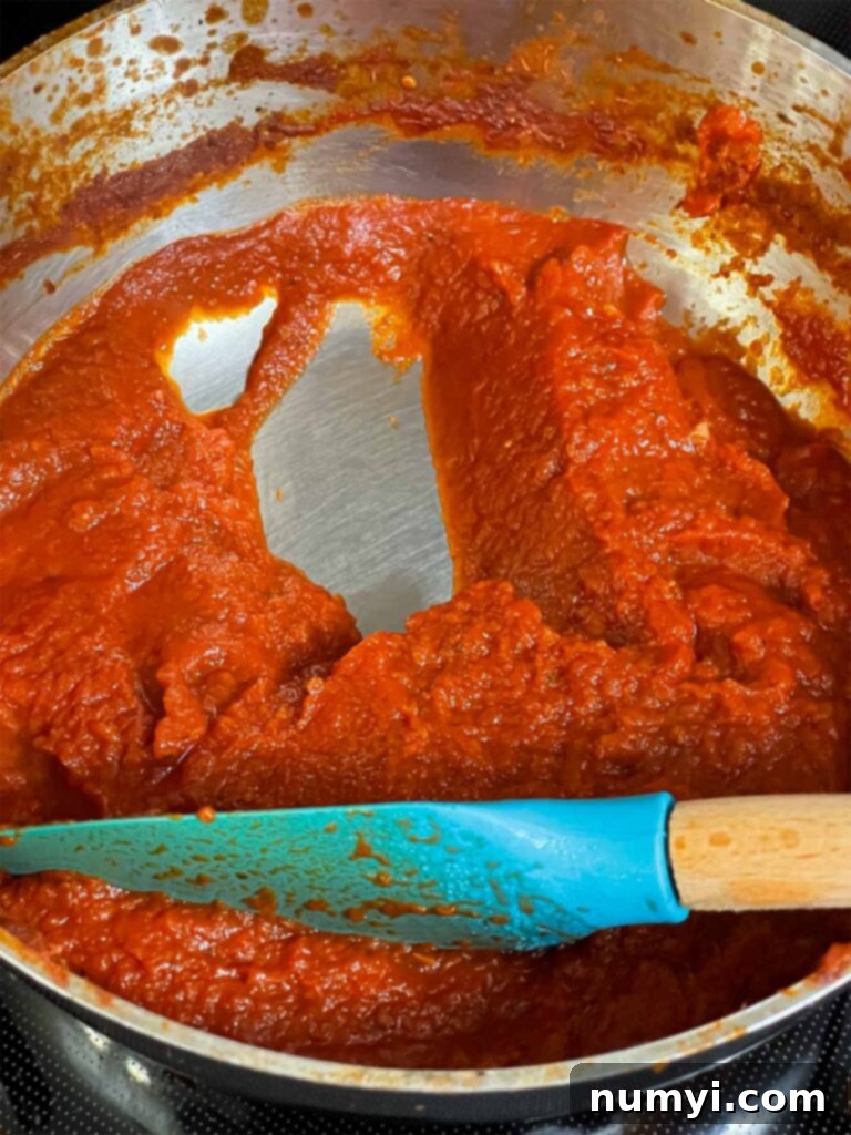 Hearty Italian Sausage Calzone 10 A perfectly thickened homemade dipping sauce for calzones, ready to serve in a saucepan, showcasing its rich texture.