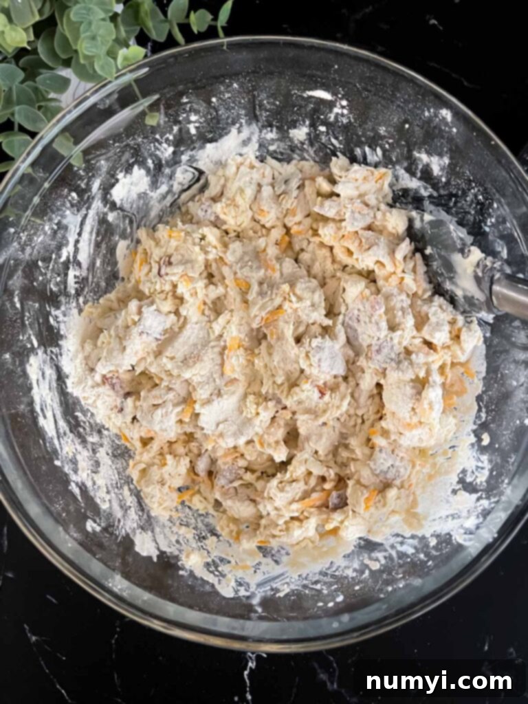 Bacon cheddar biscuit dough mixed in a glass mixing bowl.