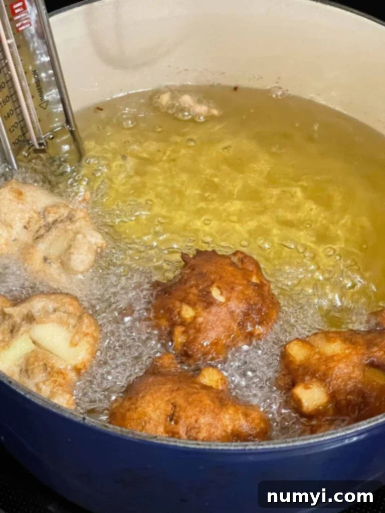 Sweet Apple Puffs 7 Apple fritters frying in a large dutch oven.