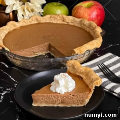 Homemade Apple Butter Pie 11 Apple butter pie with a sliced on a dark plate, garnished with whipped cream.