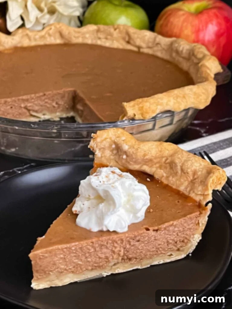 Homemade Apple Butter Pie 9 Apple butter pie with a sliced on a dark plate, garnished with whipped cream.
