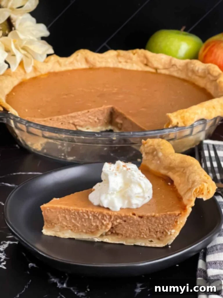 Homemade Apple Butter Pie 10 Apple butter pie with a sliced on a dark plate, garnished with whipped cream.